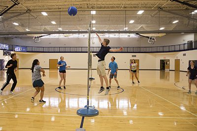 Students in a gym class playing volleyball