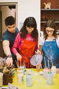 Three students working in art