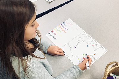 Lower school French class making maps of France for geography unit