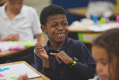 Joyful elementary student doing math