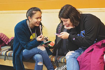 Two students sitting with phones