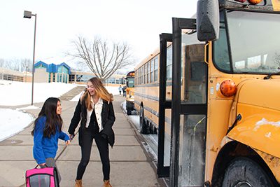 middle school students getting on the bus