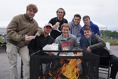 young alums around the bonfire at homecoming 2018