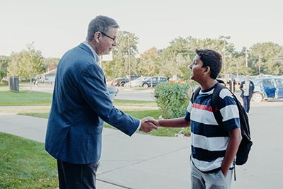 dr. Hudson shaking the hand of a middle school student on the first day of school