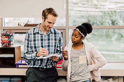 Middle school teacher and students discuss a math problem in class