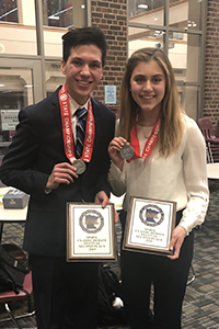 Two students holding awards