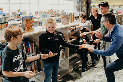 dr. Hudson with students passing the books into the new library