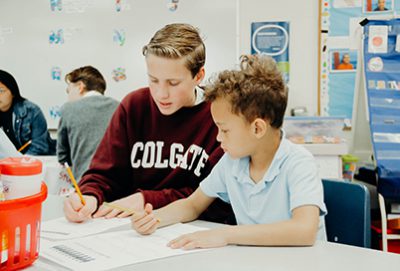 ninth grader and first grade student working together