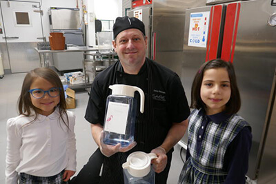 Chef Doug with the lower school students and maple syrup