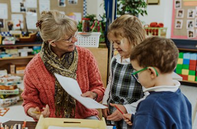 ms. Petersen working with two kindergarten students in class