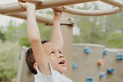 lower school student on the playground monkey bars