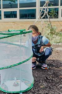 4th Grader Studying Butterflies in Courtyard