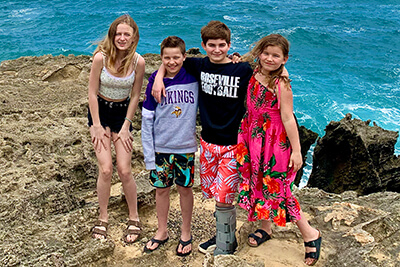 Ava, Andrew, Ari, and Annika Roseth in front of the ocean