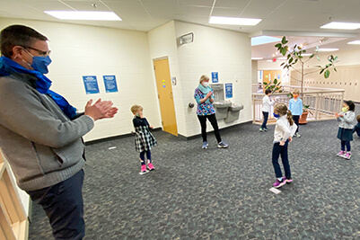 Kindergartners gifting Dr. Hudson a scarf 