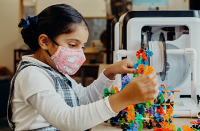 lower school student building with engineering tools