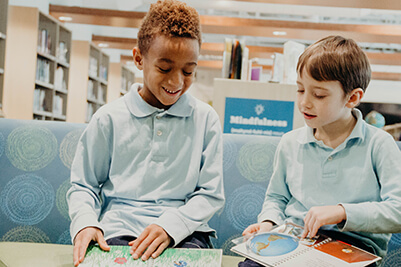 two students reading in the library in 2019