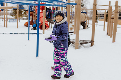 student playing in the snow at recess