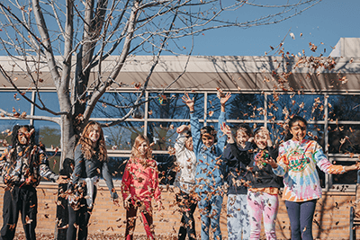 middle school students playing in the leaves